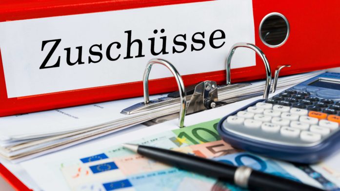 Erneut Zuschüsse für barrierereduziertes Umbauen? Unser Foto zeigt einen Ordner mit der Beschriftung "Zuschüsse" auf einem Schreibtisch
